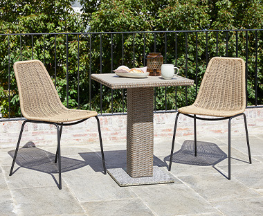 Kleiner Gartentisch mit zwei Gartenstühlen auf einer Terrasse