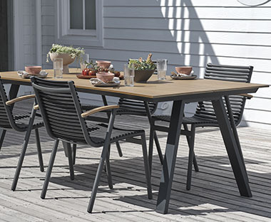 Gartentisch mit einer Tischplatte aus Kunstholz auf einer Terrasse