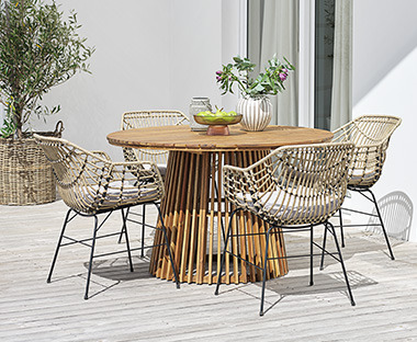 Runder Gartentisch mit stylischen Gartenstühlen auf einer Terrasse