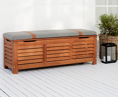 Auflagenbox aus Holz mit gepolsterter Sitzfläche auf einer Terrasse