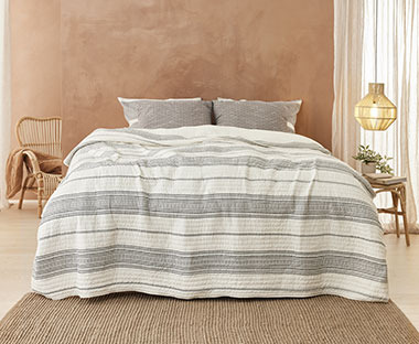 Tagesdecke mit gestreiften Muster auf einem Bett