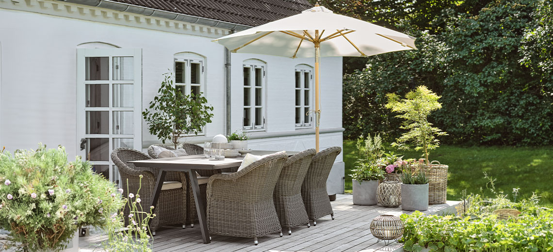 Sonnenschirm auf der Terrasse im Garten mit Gartentisch und Gartenstühlen