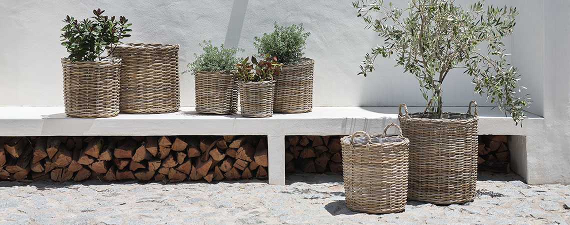 Pflanzgefäße und Blumentöpfe aus Rattan auf einer Terrasse