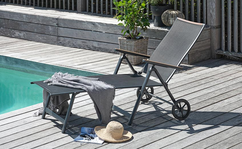 Sonnenliege auf einer Terrasse vor einem Pool