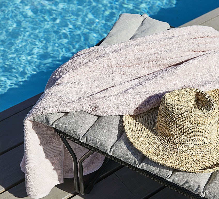 Sonnenliege mit Kissen an einem Schwimmbad 