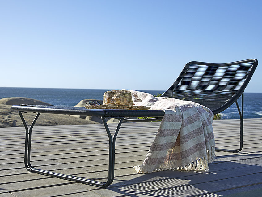 Sonnenliege auf einer Holzterrasse am Meer