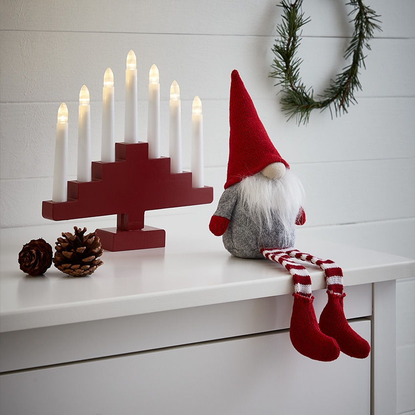 Weihnachtswichtel mit weißem Bart, spitz zulaufender roter Mütze und Strümpfen