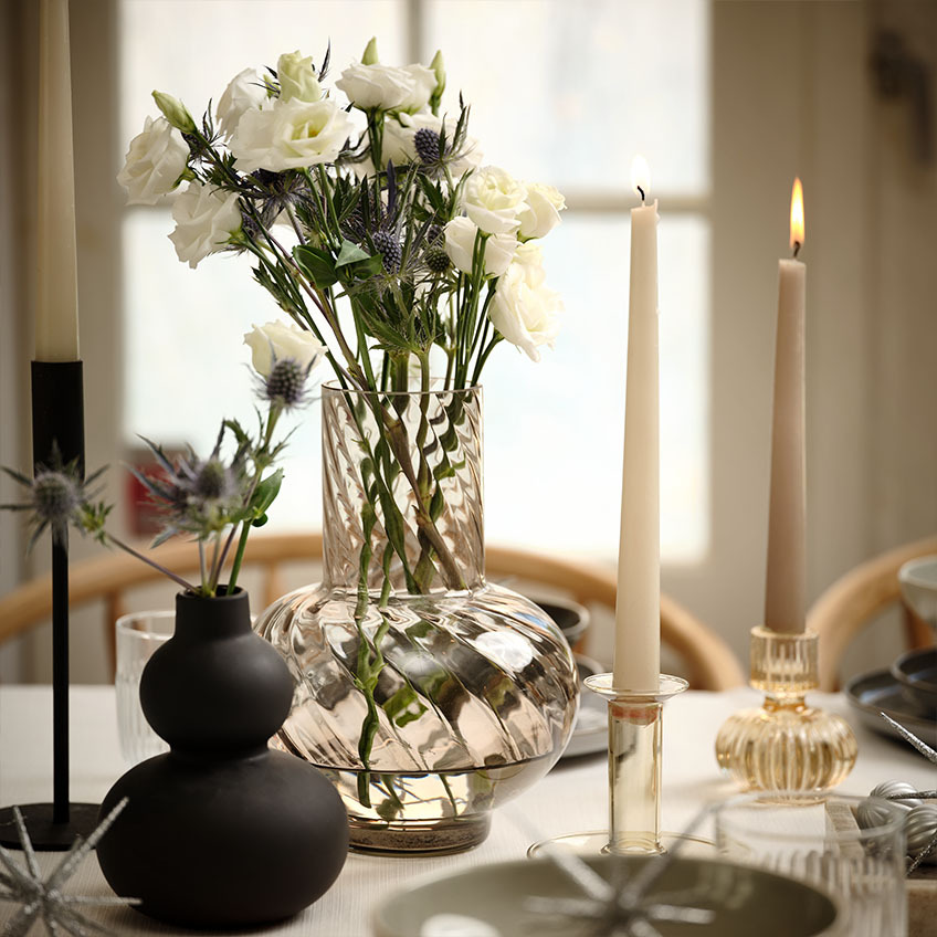Schwarze Vase und Glasvase mit Blumen auf einem Neujahrsfest