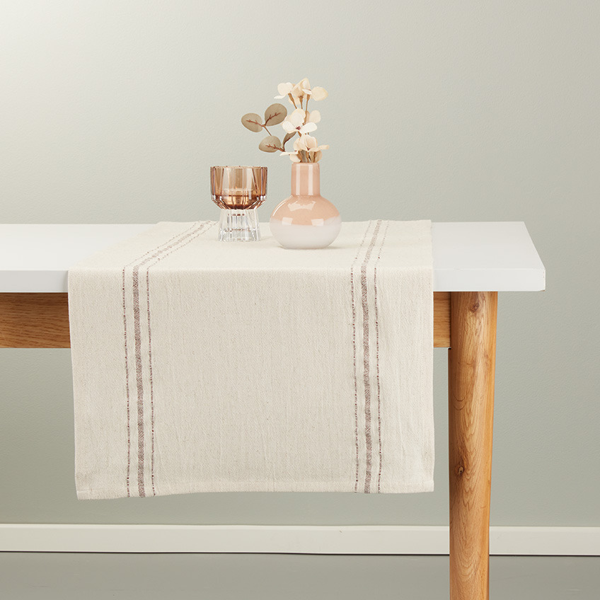 Tischläufe im Leinen-Look in warmem Beige mit burgundroten Details auf einem Esstisch