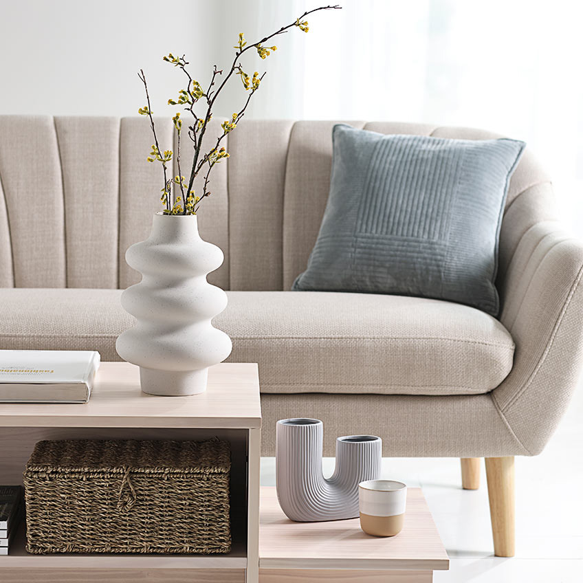 Vase Alvis und TORMUND bringen mit ihrer organischen Form viel Schwung in die Frühlingsdeko Vasen in geschwungenem Design auf einem Couchtisch vor einem gemütlichen Sofa