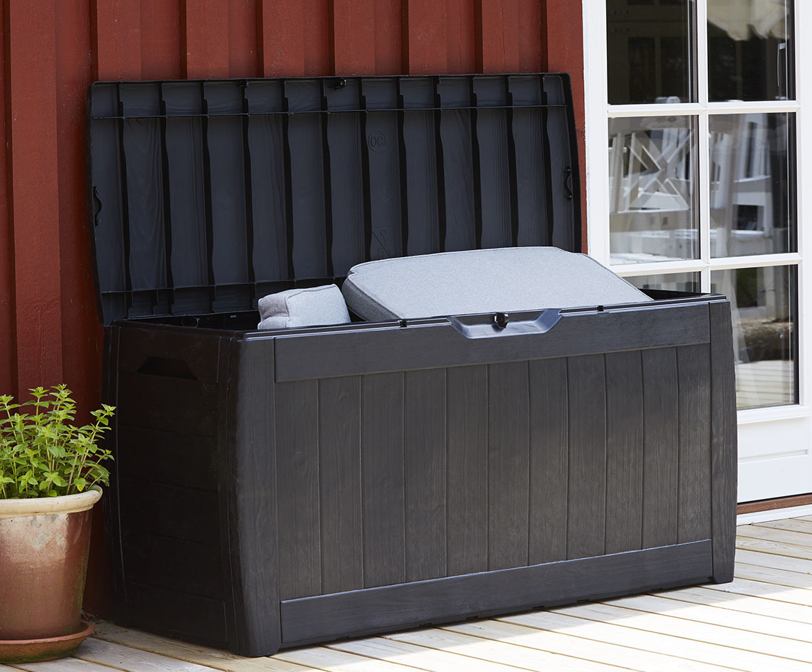 Schwarze Aufbewahrungsbox mit offenem Deckel auf einer Terrasse