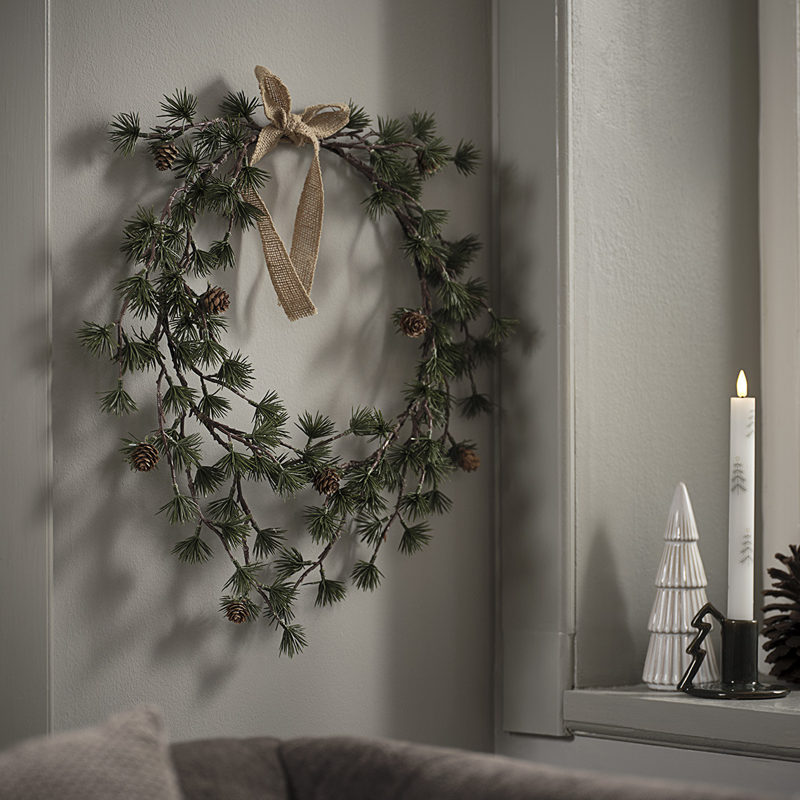 Weihnachtskranz auf der Fensterbank mit Weihnachtsdeko Baum und Weihnachtskerze