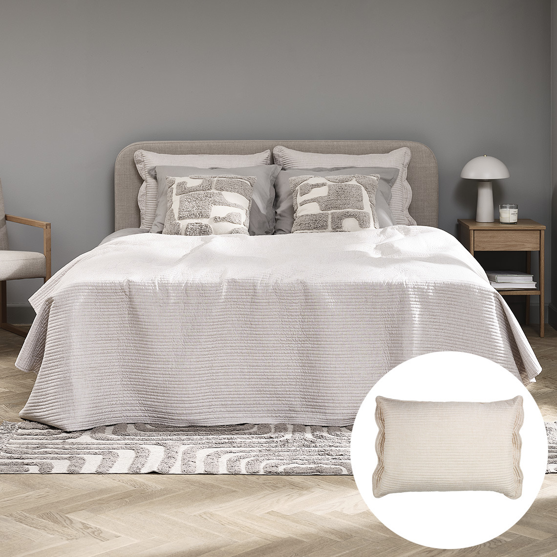 Schlafzimmer mit großem Bett mit Tagesdecke und Zierkissen in Beige