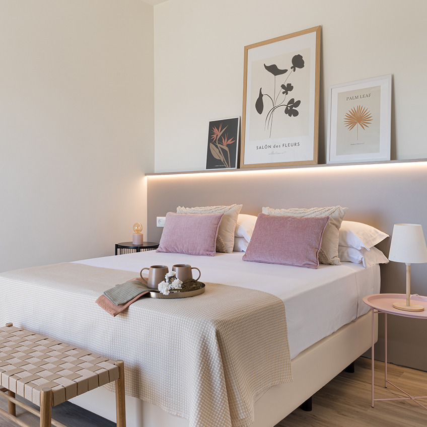 VADEHAVET Bank, RANDERUP Beistelltisch, JULIUS Tischlampe, EGELEV Nachttisch, ARNOLD Batterielampe, HORNFIOL Kissen, KORNBLOMST Bettüberwurf, TORD Bilderrahmen und OSCAR Bilderrahmen Möbliertes Schlafzimmer mit Bett, Bank und Dekoration
