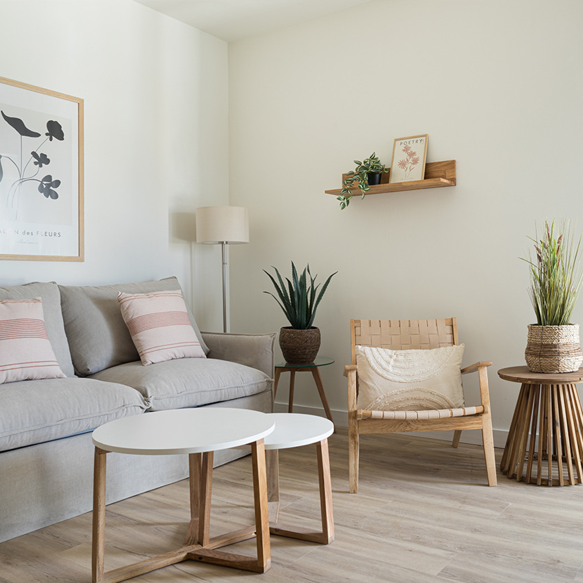VADEHAVET Sessel, SVENSTRUP Beistelltische, KRISTOF Stehlampe, TORD Bilderrahmen, JYSTED Wandregal, NATTLILJA Kissen und GODSKE Kunstpflanze Wohnbereich mit Sofa, Sessel, Couchtischen und Dekoration