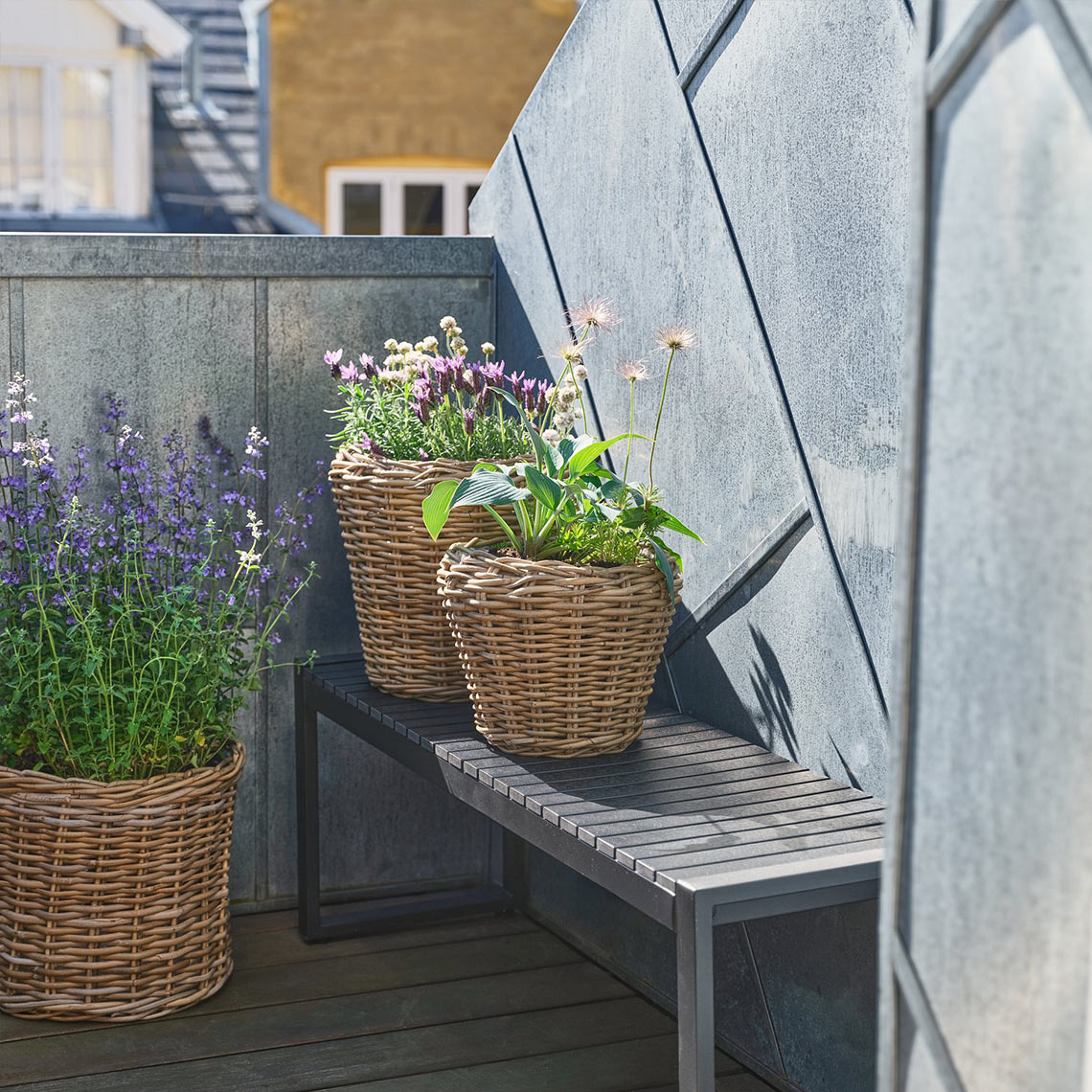 Gartenbank SAUNTE Gartenbank aus Metall auf einem kleinen Balkon mit Pflanzen und Pflanzgefäßen