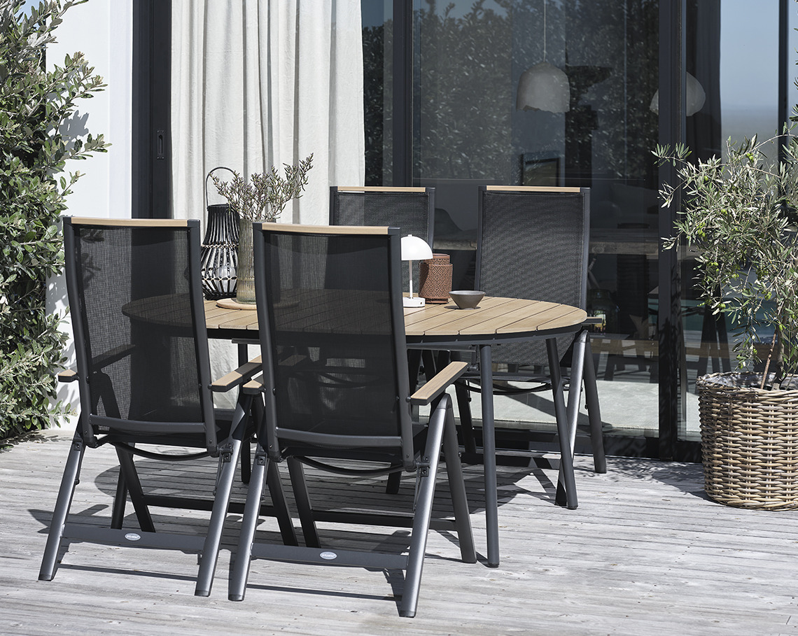 Ovaler Gartentisch mit Gartenstühlen auf einer Terrasse