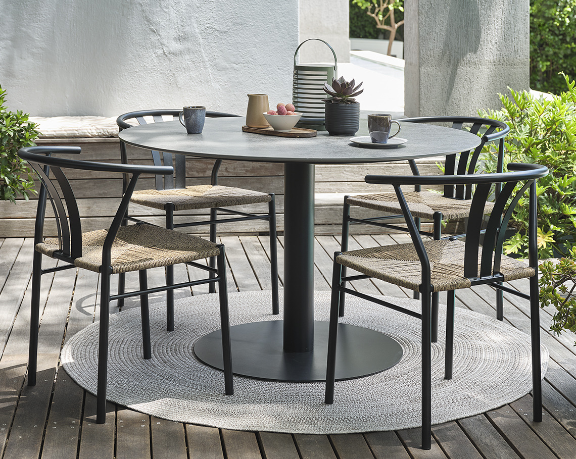 Gartentisch mit Sockel und vier Gartenstühlen auf einer Terrasse