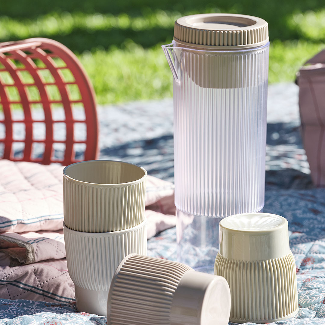 TJIM Picknick-Krug mit vier passenden Bechern Picknickzubehör, darunter eine Kanne mit vier passenden Bechern auf einer Picknickdecke