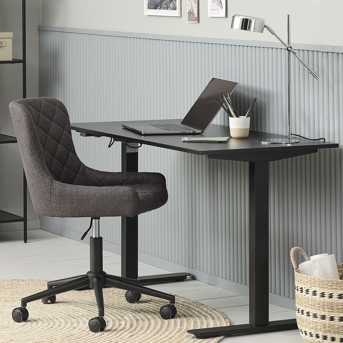 Höhenverstellbarer Schreibtisch und Bürosessel im Home Office
