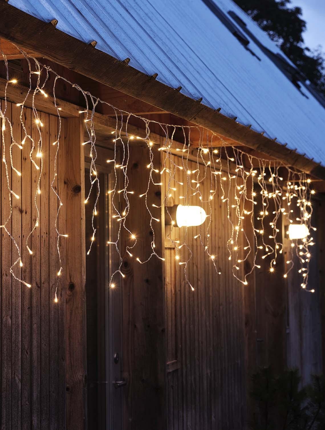 Eiszapfen-Lichterkette SNOTRA mit integriertem Timer Eiszapfen-Lichterkette, die in der Dunkelheit leuchtet und an der Fassade eines Hauses hängt
