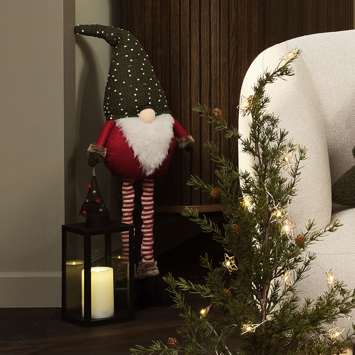 Höhenverstellbarer Wichtel KULDE Höhenverstellbarer Wichtel mit einer Laterne neben einem Sofa