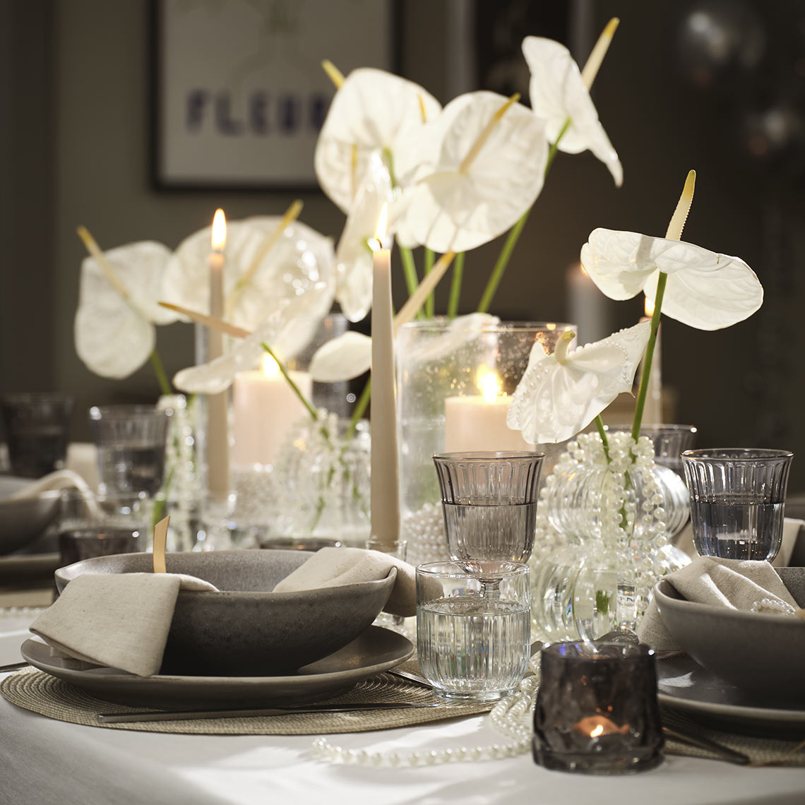 Gedeckter Tisch mit Schalen, Tellern, Gläsern und Teelichthaltern