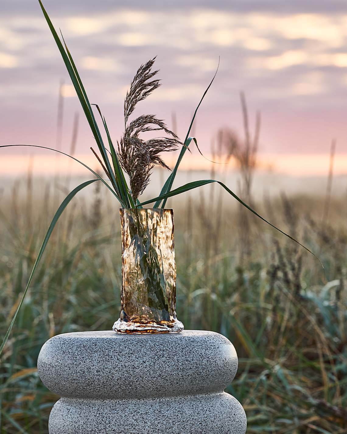 Hohe Vase auf Sockel in den Dünen nahe einem Strand    