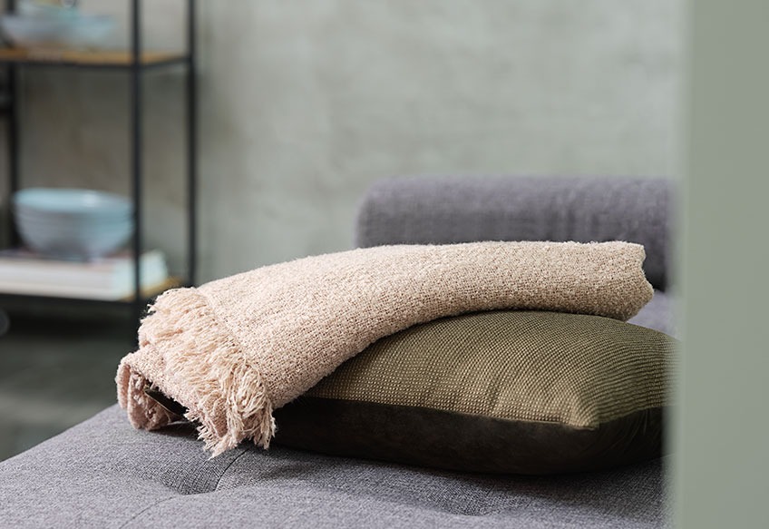 Eine Decke und ein Kissen auf einem Sofa 