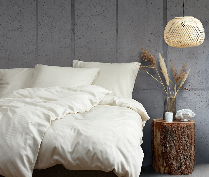 Elegantes Schlafzimmer im ruhigen skandinavischen Look mit Bett aus sandfarbener Bettwäsche