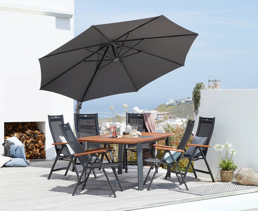 Terrasse mit einem hängenden Sonnenschirm über einem Gartenset