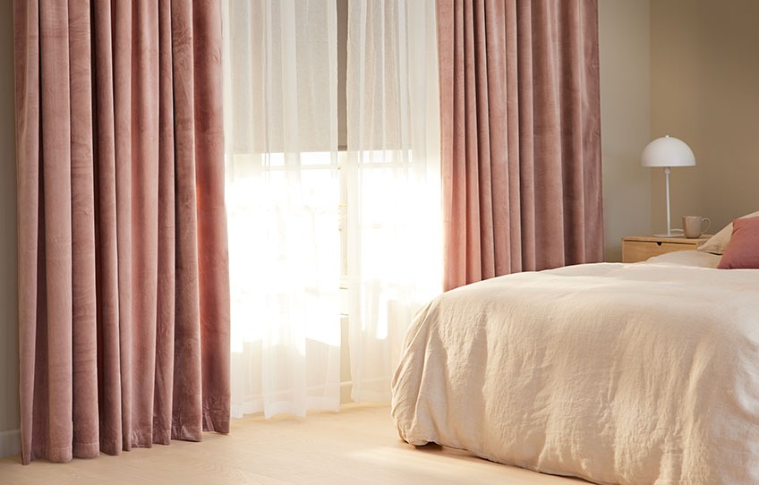 Schlafzimmer mit Verdunkelungsrollo auf halbem Weg nach oben mit lichtdurchlässigem Vorhang 