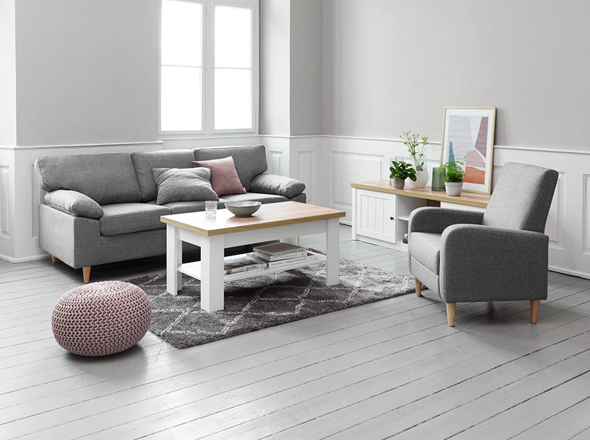 Wohnzimmer mit grau/weißen Couchtisch und TV-Bank mit Sofa und Sessel in Grau