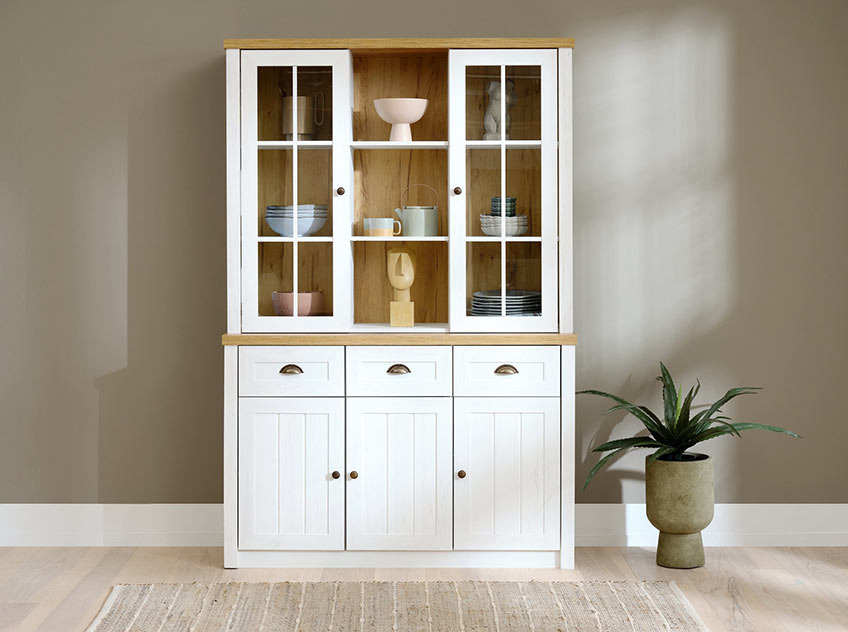 Buffetschrank MARKSKEL setzt sich aus einer Anrichte und einem Aufsatz zusammen Buffetschrank mit Geschirr und Deko vor einer grünen Wand