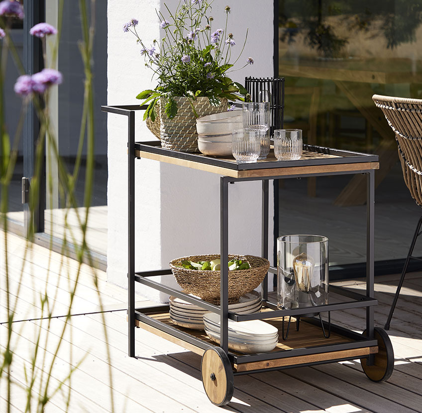Trolley mit Tellern und Gläsern auf einer Terrasse