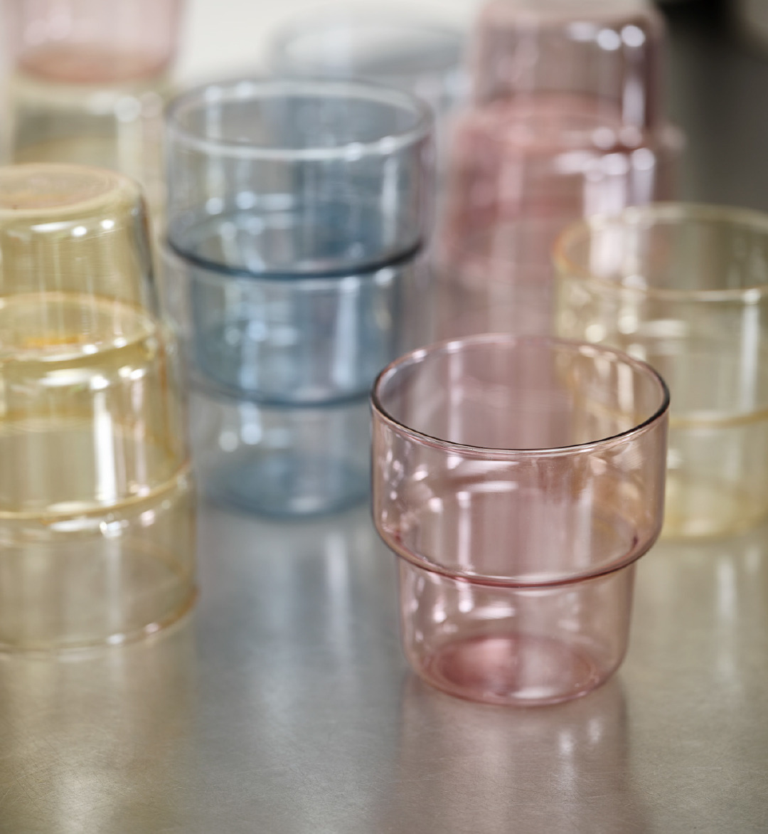 Wassergläser in drei verschiedenen Farben auf einem Tisch