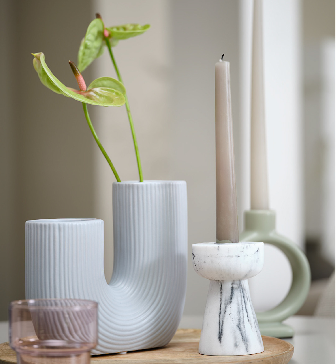 Tischdekoration mit einer Vase und drei Kerzenhaltern