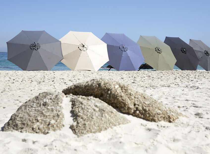 Sonnenschirme in verschiedenen Farben an einem Strand 