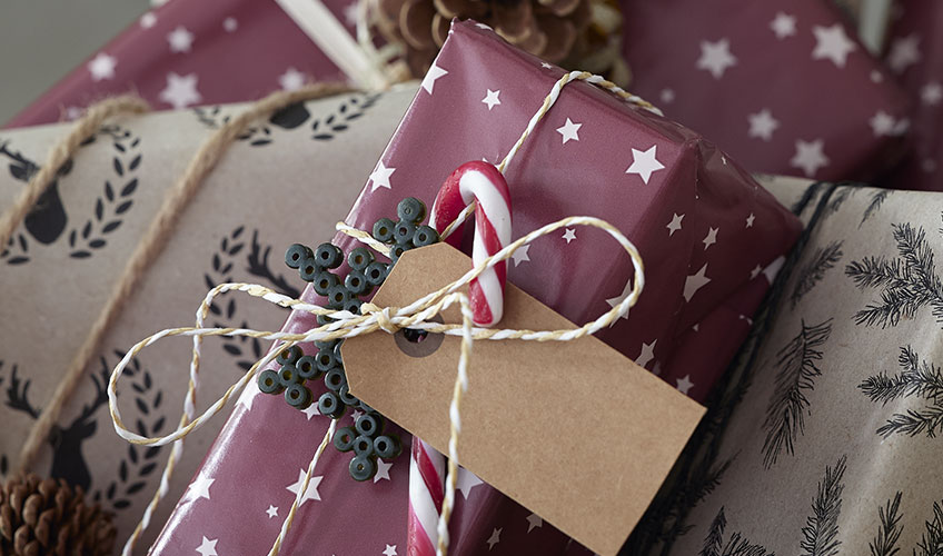 In Papier eingewickeltes Weihnachtsgeschenk, verziert mit Zuckerstangen und Bügelbilder