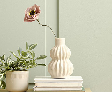 Vase im modernen Stil mit einer Kunstblume aus Papier auf einem Tisch