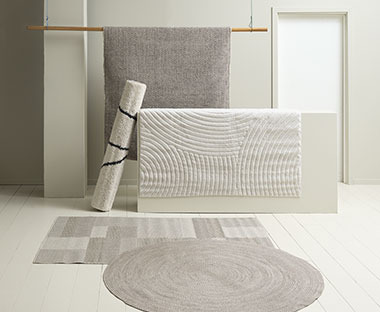 Teppiche in den Farben Beige und Grau auf dem Boden und einem Potest