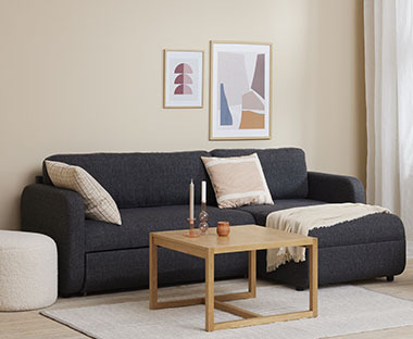 Ausziehbares Sofa mit Stauraumfunktion und ein Couchtisch aus Holz